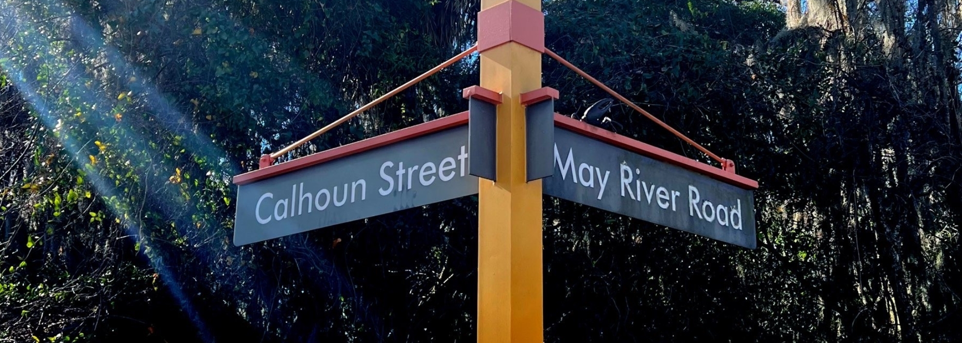 Image of yellow pole with signs on each side that read Calhoun Street and May River Road